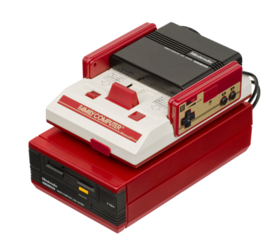The Famicom Disk System sitting atop a Nintendo Famicom.