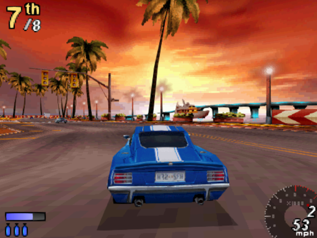 A blue car races on a tropical street toward an orange sunset.
