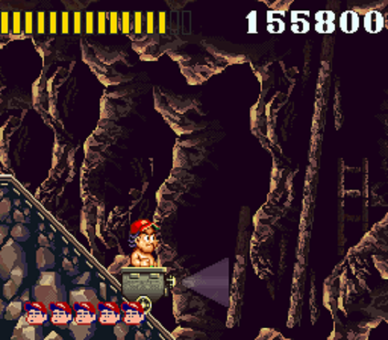Master Higgins rides through a dark cave in a mine cart.